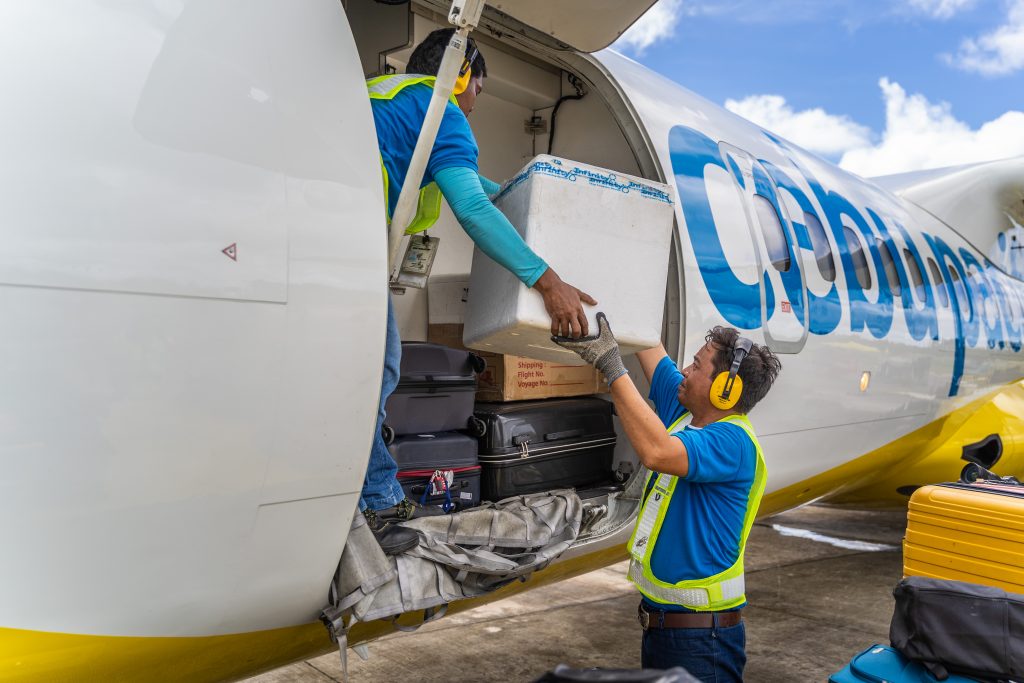 Men loading cargo hold of an ATR turboprop